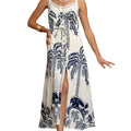 Woman wearing a white dress with blue leaf patterns in an outdoor setting.