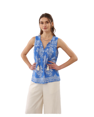 Woman wearing a blue patterned top and beige pants on a transparent background