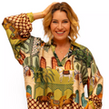 Woman wearing a colorful patterned blouse with a white background
