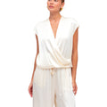 Woman wearing a white jumpsuit on a plain background