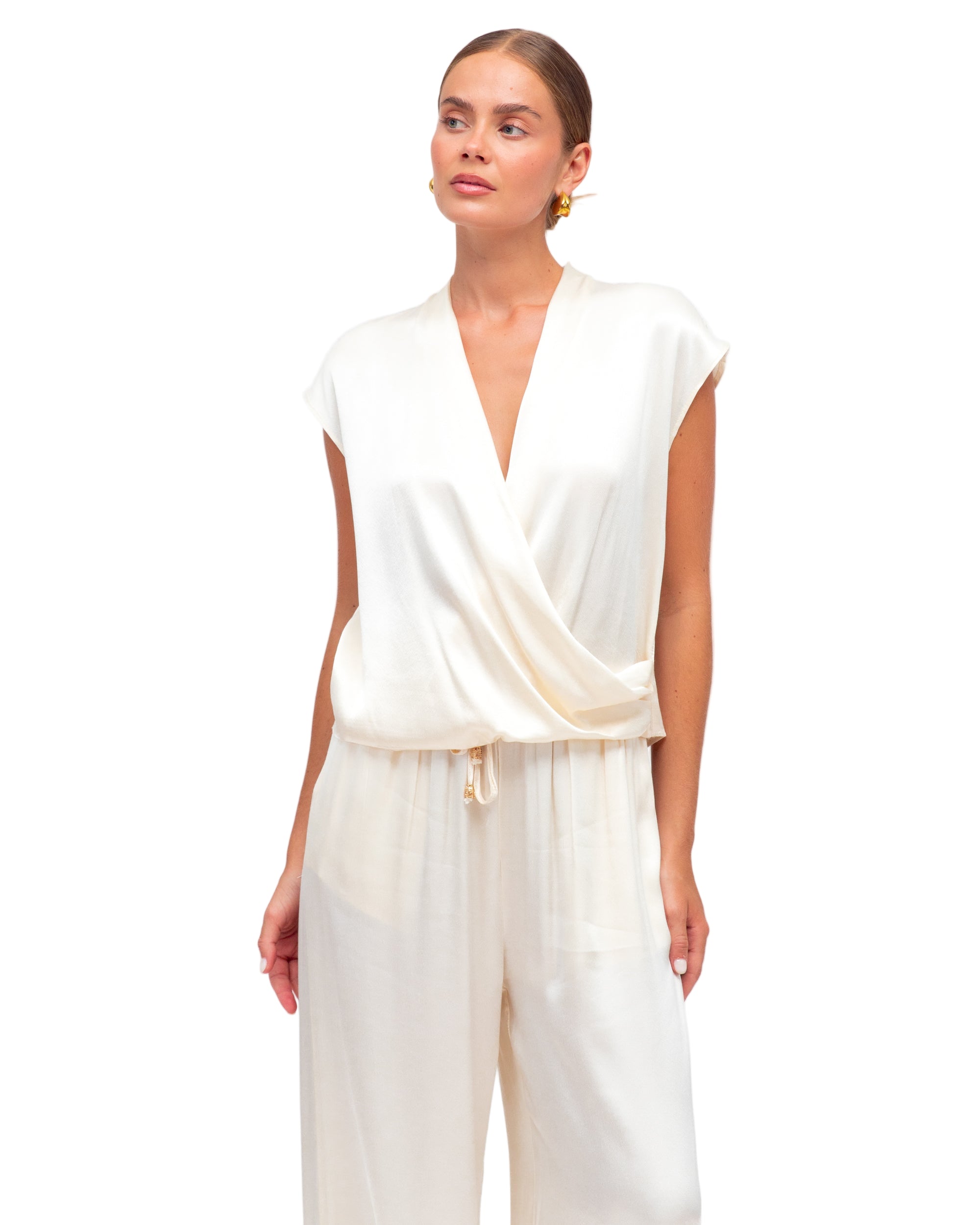 Woman wearing a white jumpsuit on a plain background