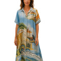 Woman wearing a colorful dress with a scenic design on a street.