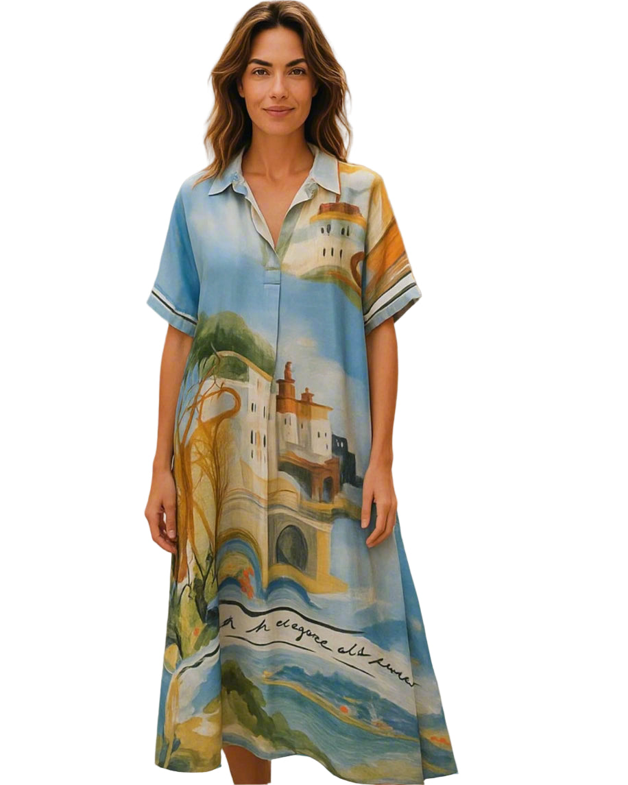 Woman wearing a colorful dress with a scenic design on a street.